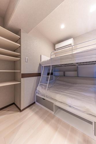 a small room with bunk beds in it at 海の見える高層階グループファミリー歓迎コストコ近くThe琉球タワー9A in Yonabaru