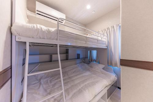 a small room with two bunk beds in it at 海の見える高層階グループファミリー歓迎コストコ近くThe琉球タワー9A in Yonabaru