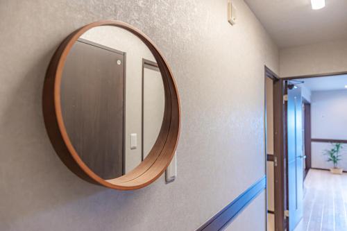a round mirror on a wall in a hallway at 海の見える高層階グループファミリー歓迎コストコ近くThe琉球タワー9A in Yonabaru