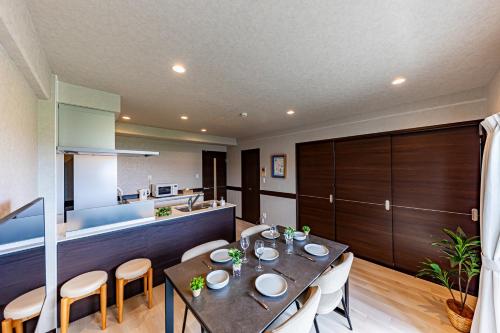 a kitchen and dining room with a table and chairs at 海の見える高層階グループファミリー歓迎コストコ近くThe琉球タワー9A in Yonabaru