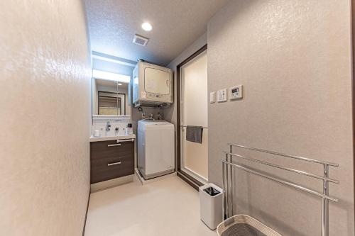 a small kitchen with a refrigerator and a tv at 海の見える高層階グループファミリー歓迎コストコ近くThe琉球タワー9A in Yonabaru