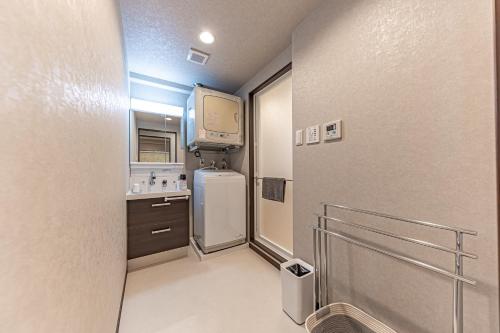 a small kitchen with a refrigerator and a tv at 海の見える高層階グループファミリー歓迎コストコ近くThe琉球タワー9A in Yonabaru