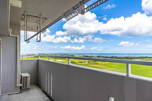 a balcony with a view of the ocean at 海の見える高層階グループファミリー歓迎コストコ近くThe琉球タワー9A in Yonabaru