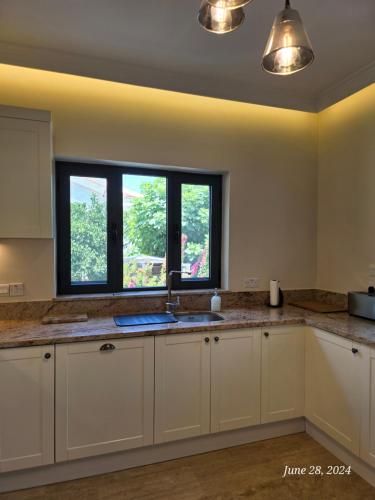 a kitchen with white cabinets and a window at Villa Kyrenia in Lapithos