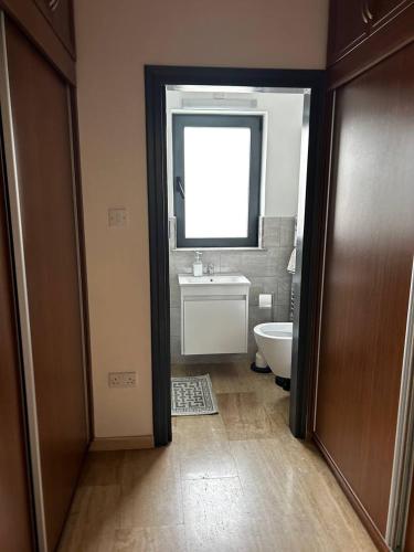 a bathroom with a toilet and a sink and a window at Villa Kyrenia in Lapithos