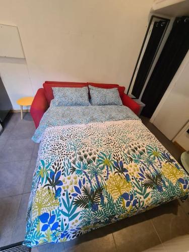 - un lit avec une couverture et des oreillers colorés dans l'établissement Cosy studio near to Paris and Orly airport, à Vitry-sur-Seine