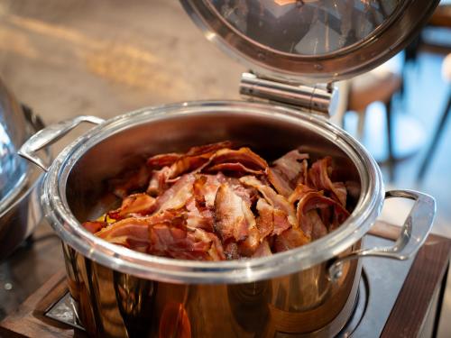 a pot full of food sitting on a stove at Hôtel du Golf de l'Ailette, The Originals Relais in Chamouille