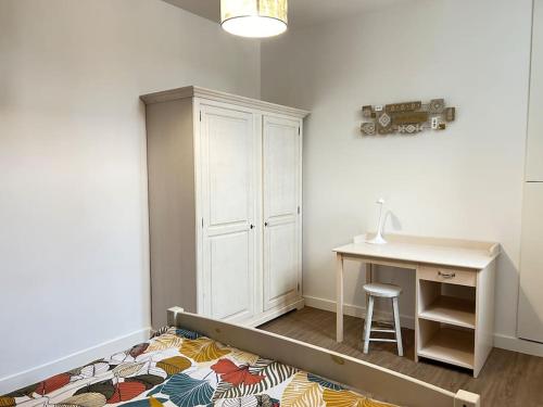 a room with a desk and a table and a desk and a rug at Appartement 2 chambres en centre-ville in Parthenay