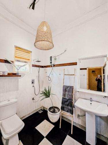 a bathroom with a sink and a toilet and a potted plant at Sugar Hostel Weligama - Coliving & Coworking in Weligama