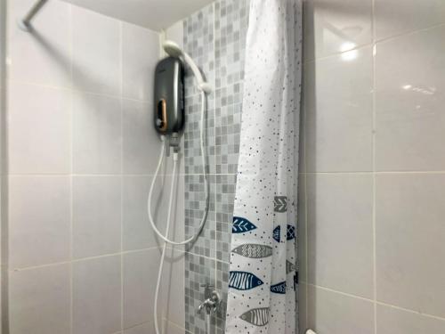 een douchegordijn met een telefoon in de badkamer bij Relaxing 2BR at 35th Floor Tokyo Riverside PIK 2 Apartment By Travelio in Rawalembang