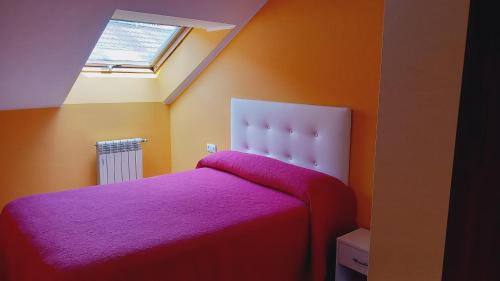 Un dormitorio con una cama con una manta morada. en Cangas Alameda, en Cangas de Onís