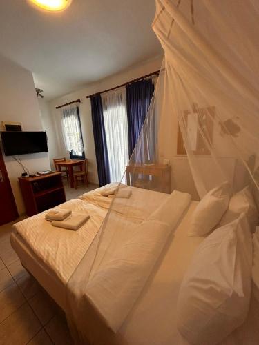 a bedroom with a white bed with a canopy at Finikas Studios & Apartments - Kalamaki Holidays in Kalamaki