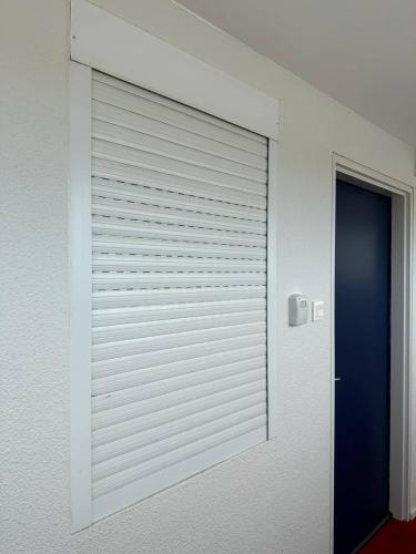 une porte de garage blanche dans une chambre avec une porte dans l'établissement Appartement vue mer, clim, wifi et parking - 4BEAU418, à Canet