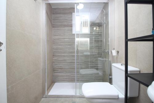 a bathroom with a glass shower with a toilet at Del Parque Flats Family Paradise in Rincón de la Victoria