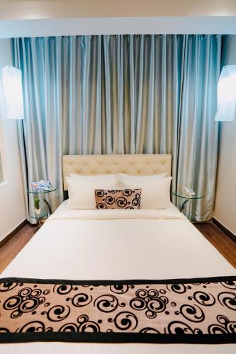 a bedroom with a large bed with blue curtains at Royal Residence Dhaka in Dhaka