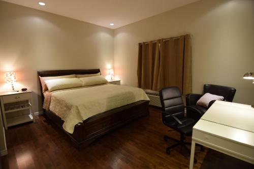 een slaapkamer met een bed, een bureau en een stoel bij The Lion Inn & Suites in Chetwynd