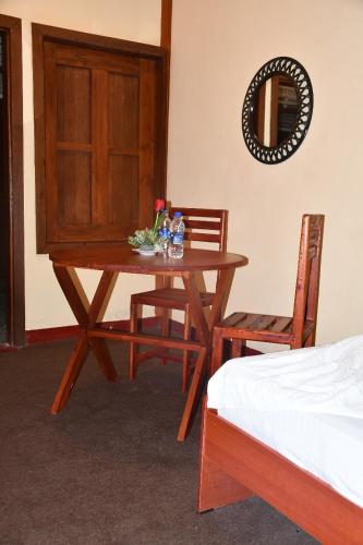 a wooden table with two chairs and a mirror at Cinnamon Airport Residencies in Katunayaka