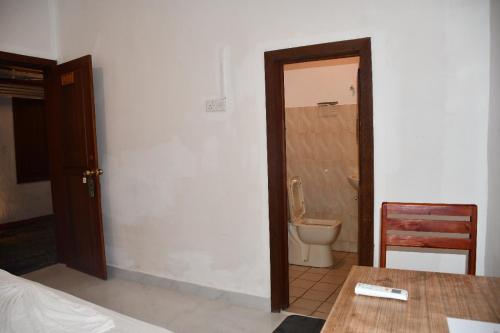 a room with a bathroom with a toilet and a table at Cinnamon Airport Residencies in Katunayaka