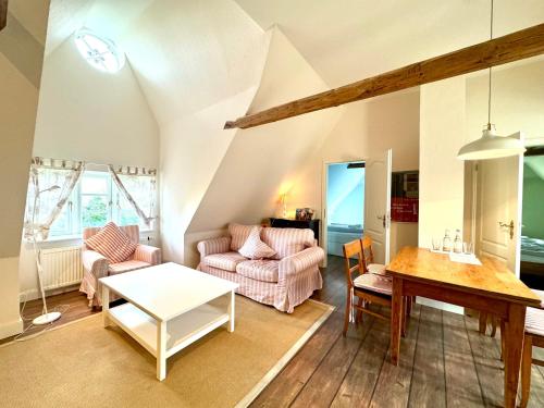 a living room with a couch and a table at Altes Standesamt Große Wohnung in Oldsum