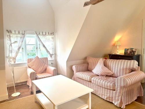 a living room with two couches and a table at Altes Standesamt Große Wohnung in Oldsum