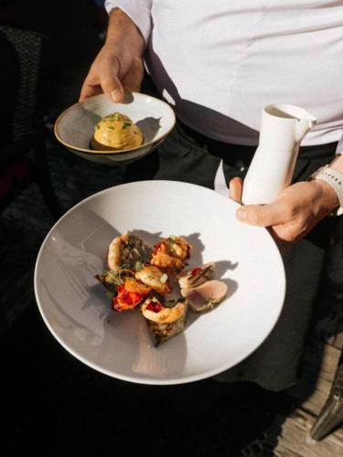a person holding a plate with food on it at Hotel Carlina in Courchevel