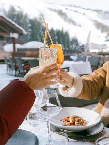 two people sitting at a table with drinks at Hotel Carlina in Courchevel