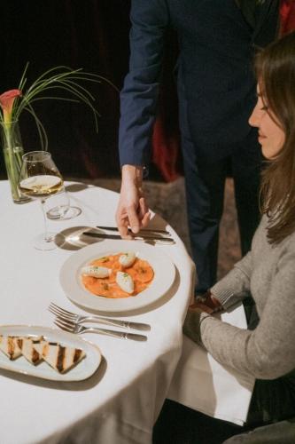 a woman sitting at a table with a plate of food at Hotel Carlina in Courchevel