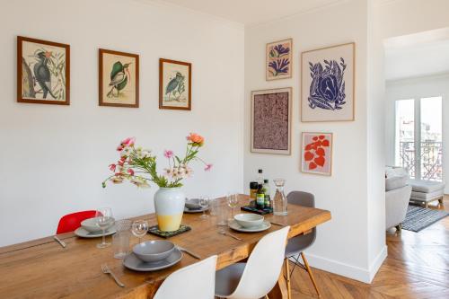 une salle à manger avec une table et des chaises en bois dans l'établissement Geranimus Parisian Charm, à Paris