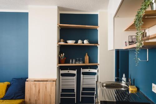 - une cuisine avec des murs bleus et un évier dans l'établissement Le bout d'chou, à Avignon