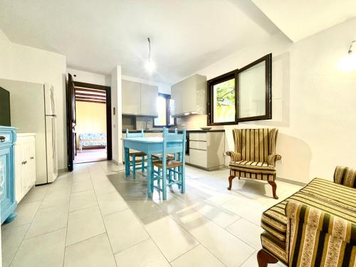 a kitchen and living room with a blue table and chairs at La Pergola Apartments in Cardedu