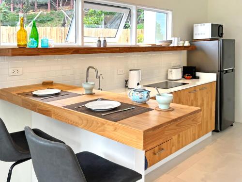 a kitchen with a wooden island with a sink at At the Beach New comfortable Pool Home, Ao Yon Beach, Phuket in Ban Ao Makham