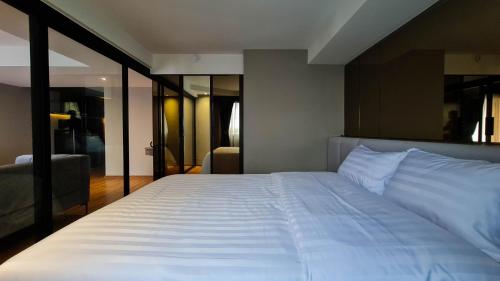 a bedroom with a large white bed in a room at We Hotel in Ban Bang Toei (1)