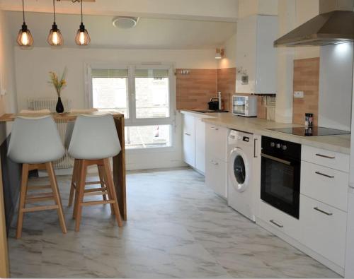 - une cuisine avec des appareils électroménagers et des comptoirs blancs dans l'établissement Une escale à la gare, à Niort