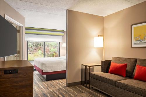 a hotel room with a bed and a couch at Hampton by Hilton Shelton in Shelton