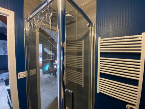 - une douche en verre dans une chambre dotée d'un mur bleu dans l'établissement Le Roule, à Cherbourg en Cotentin