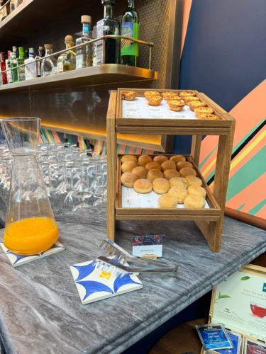 uma mesa com uma exposição de donuts e suco de laranja em DUO Hotel Lisbon, Curio Collection by Hilton em Lisboa