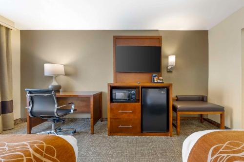 a hotel room with a desk and a tv at Comfort Inn South - Springfield in Springfield