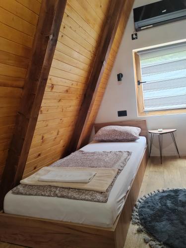 two beds in a room with a wooden wall at Jerry's Forest in Banja Luka