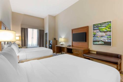 a hotel room with two beds and a flat screen tv at Comfort Inn & Suites Valdosta I-75 in Valdosta
