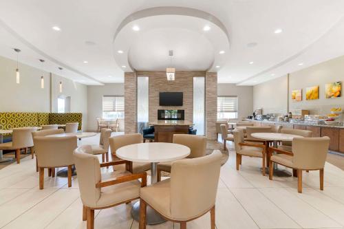 a restaurant with tables and chairs and a bar at Comfort Inn & Suites Valdosta I-75 in Valdosta