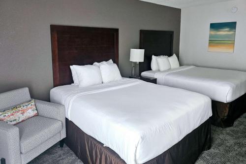 a hotel room with two beds and a chair at Comfort Inn Plymouth-Minneapolis in Plymouth