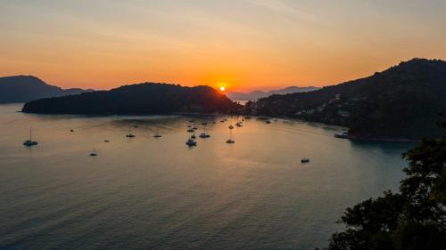 a group of boats in the water at sunset at At the Beach New comfortable Pool Home, Ao Yon Beach, Phuket in Ban Ao Makham