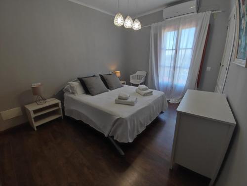 a bedroom with a white bed and a window at Son Massanet con Piscina y Fantásticas Vistas, ideal para ciclistas y senderistas in Campanet