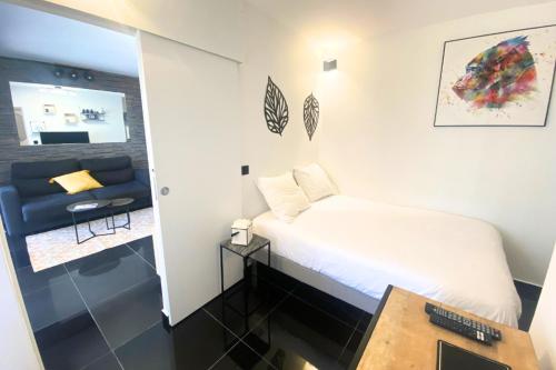 une petite chambre avec un lit et un canapé dans l'établissement Cosy 2 pièces - Palais Croisette Cannes, à Cannes