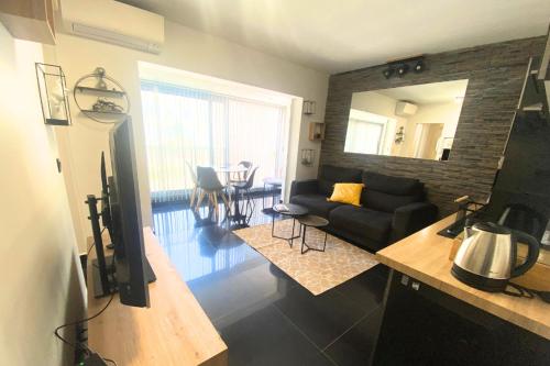 - un salon avec un canapé noir et un miroir dans l'établissement Cosy 2 pièces - Palais Croisette Cannes, à Cannes