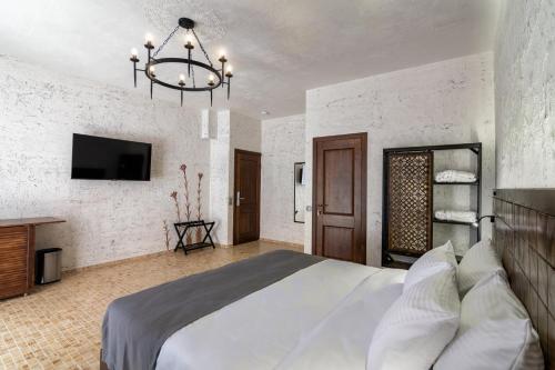 a bedroom with a large bed and a chandelier at Kazma Boutique Hotel in Tbilisi City