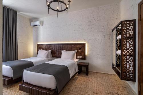 a hotel room with two beds and a chandelier at Kazma Boutique Hotel in Tbilisi City
