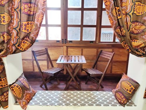 a room with two chairs and a table and a window at Treasures of Zanzibar House in Zanzibar City