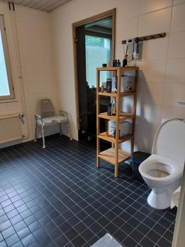 a bathroom with a toilet and a blue tiled floor at Villa Saimaan Sydän in Puumala