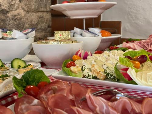 a buffet with different types of food on a table at Hotel Grüner Baum in Würzburg